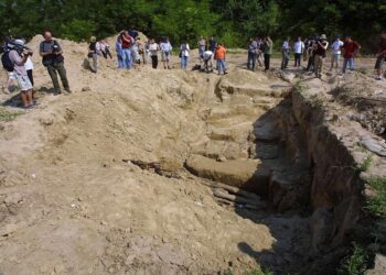 BEL02 - 20010709 - BATAJNICA, SERBI, JUGOSLLAVI: Gazetarët fotografojnë një varr masiv në Batajnicë pranë Beogradit të hënën, më 9 korrik 2001. Në fund të një shtegu të dheut të mbuluar me bimësi që gjarpëron përmes një baze të policisë speciale në periferi të Beogradit, një gropë e hapur shënon vendin ku agjentët e ish-regjimit të Slobodan Millosheviqit fshehën trupat e rreth 36 shqiptarëve të Kosovës gjatë luftës dy vjet më parë. EPA PHOTO EPA/SASA STANKOVIC/AS-ms
